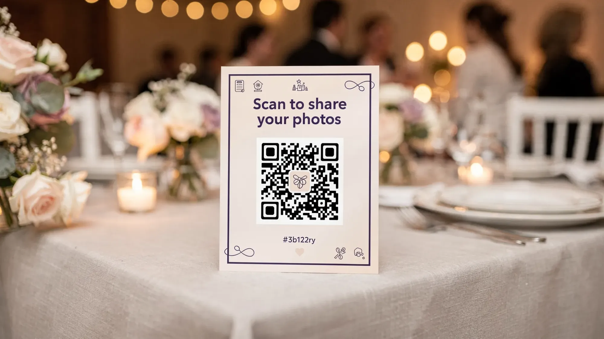 A wedding reception table with an elegant table tent sign featuring a large QR code and simple text inviting guests to scan to share photos, with floral centerpieces and warm ambient lighting in the background.