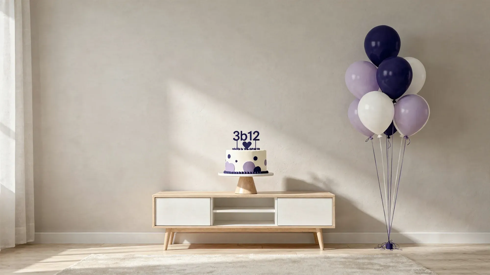 A simple birthday photo corner set up in a living room with a neutral backdrop, a small balloon cluster to one side, a cake on a pedestal stand, and soft window light coming from the left.