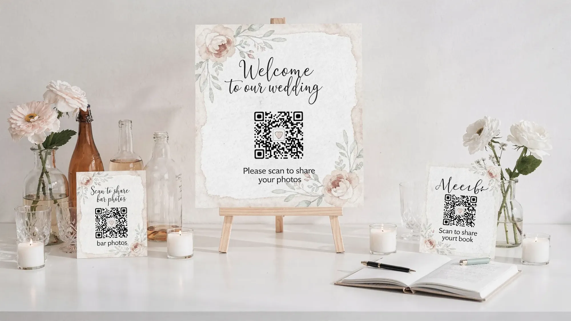 A simple wedding signage set showing a welcome sign and two smaller QR code cards placed near the bar and guest book, with clear one-line instructions for guests to scan and add photos. The scene includes soft decor elements like flowers and candles and a clean, uncluttered layout.