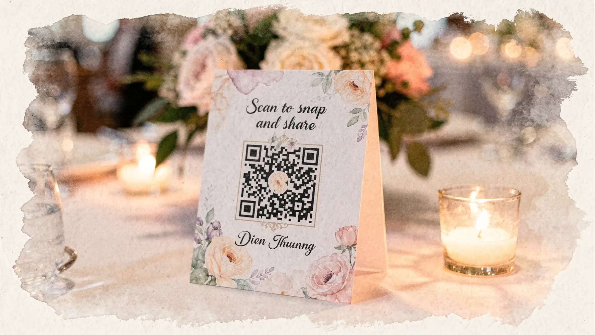 A wedding reception table tent sign with a large QR code and short instruction text like “Scan to snap and share,” placed near candles and a centerpiece, showing how guests would discover photo sharing during the event.